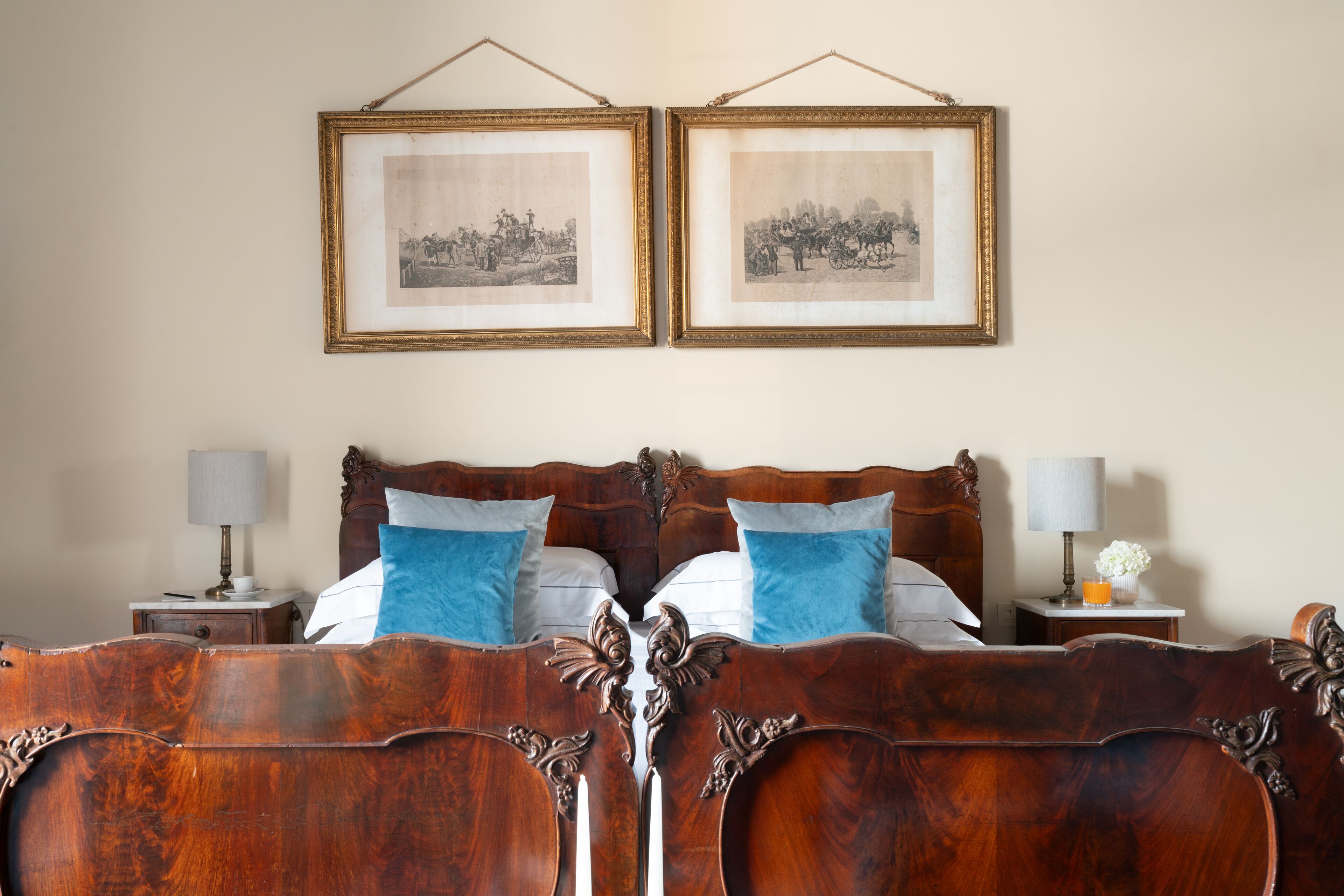 Een slaapkamer met een houten bed, twee nachtkastjes, een nachtkastje en twee ingelijste foto's aan de muur.