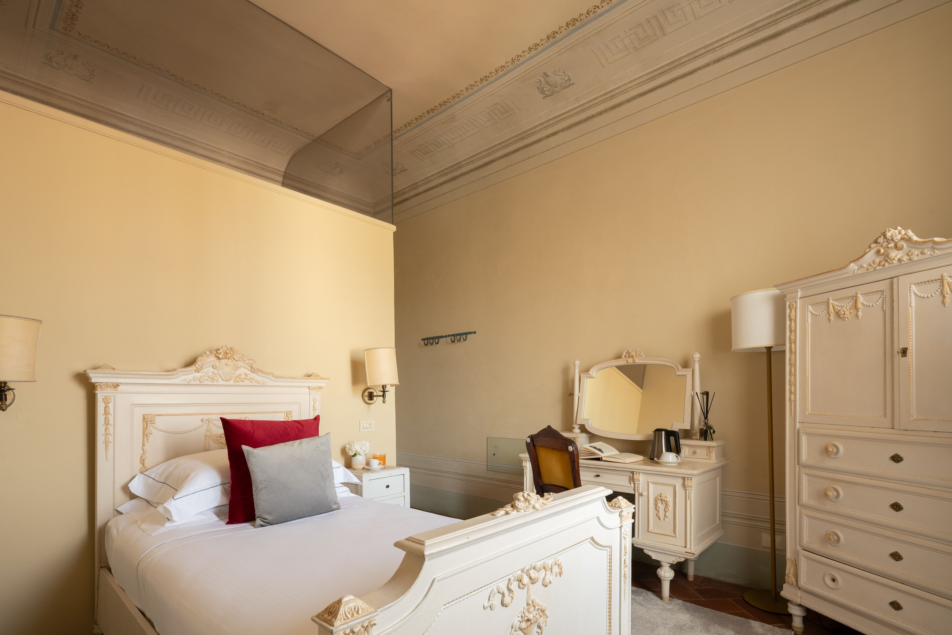 Une chambre d’hôtel avec un grand lit, une commode, un miroir et une table de chevet.