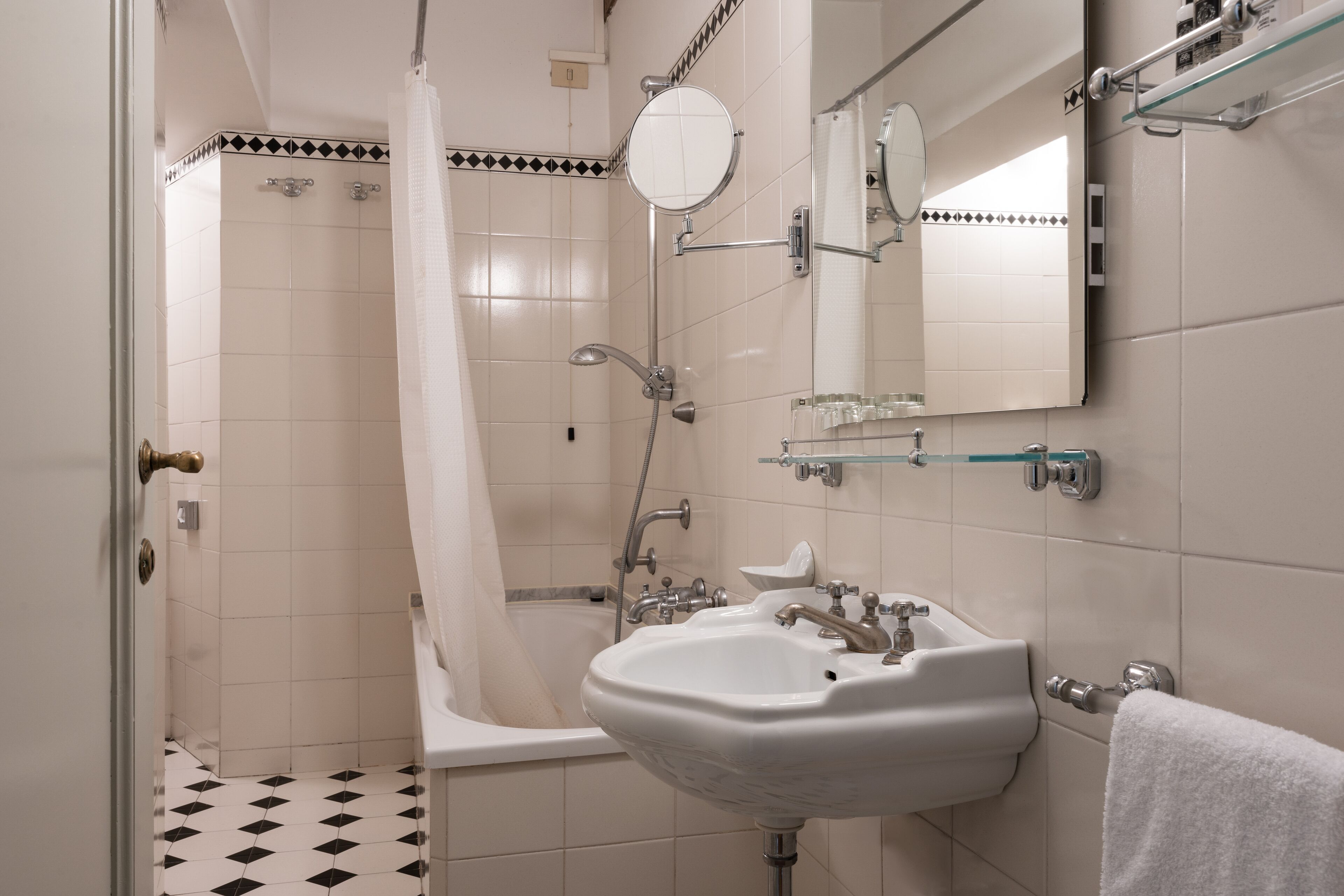 A bathroom with a bathtub, a sink, a shower, and a mirror.