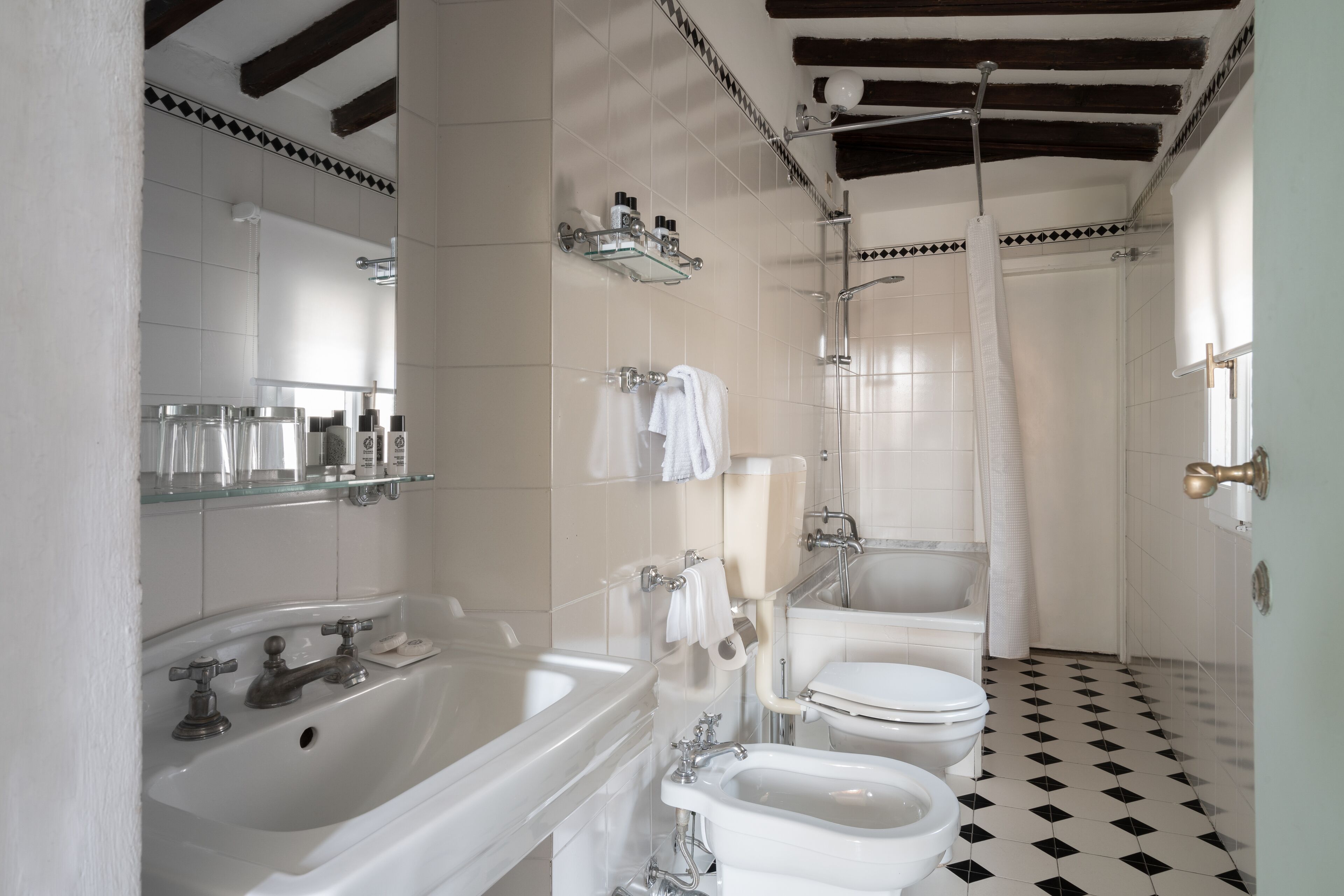 Een badkamer met een bad, wastafel, toilet en douchetoilet.
