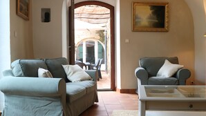 A living room with two sofas, a coffee table, and a painting on the wall.