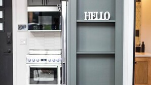 Eine Küche mit Einbauofen und einem grauen Schrank mit einem 'HELLO' Schild.