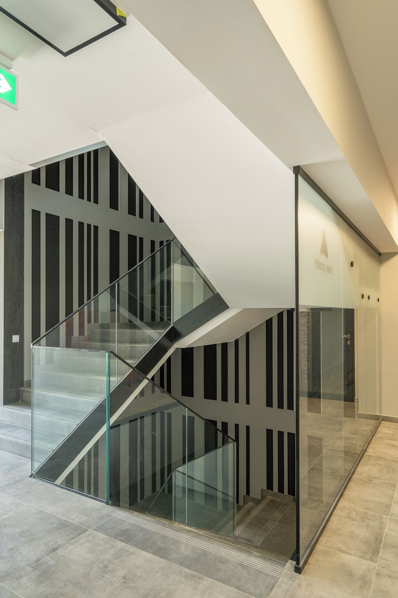 A modern staircase with glass railings and a geometric design.
