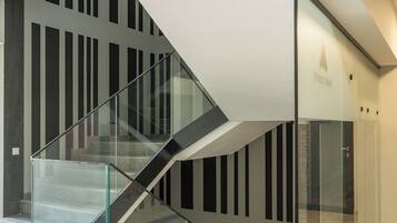 A modern staircase with glass railings and a geometric design.