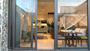 A modern interior with a dining area, kitchen, and a sleeping area with a canopy. - Cape House at Amritsar (Amritsar)