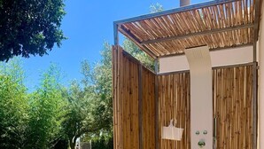 A wooden structure with a shower, a door, and a small window.