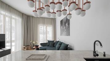 A modern kitchen with a central island, a built-in sink, and a hanging light fixture.