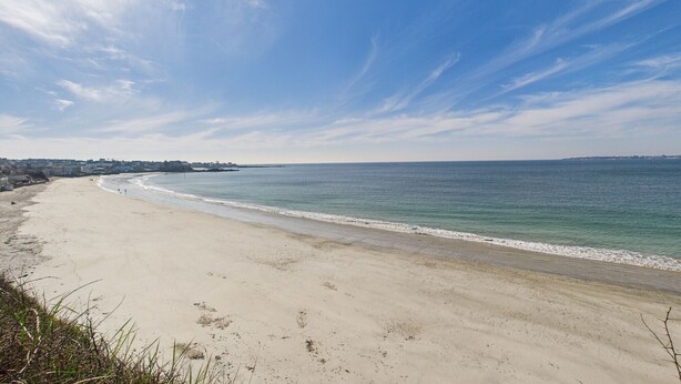A beach with a clear sky and calm sea. - -SHELBY- T2 ARRIÈRE CORNICHE PARKING ET TERRASSE (Concarneau)