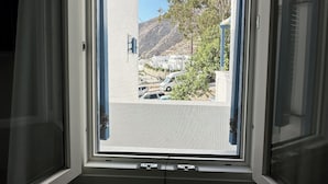 Una habitación con un ventanal grande, una puerta y una rejilla en el techo.