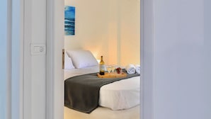 Una habitación de hotel con cama, mesita de noche y lámpara colgante.