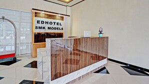 A reception desk with a sign for 'EDHOTEL SMK MODELS'. - OYO 91997 Edhotel Smk Models Syariah (Kesilir)