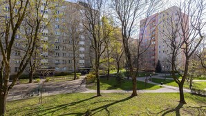 Un parque con senderos, árboles y un edificio al fondo.