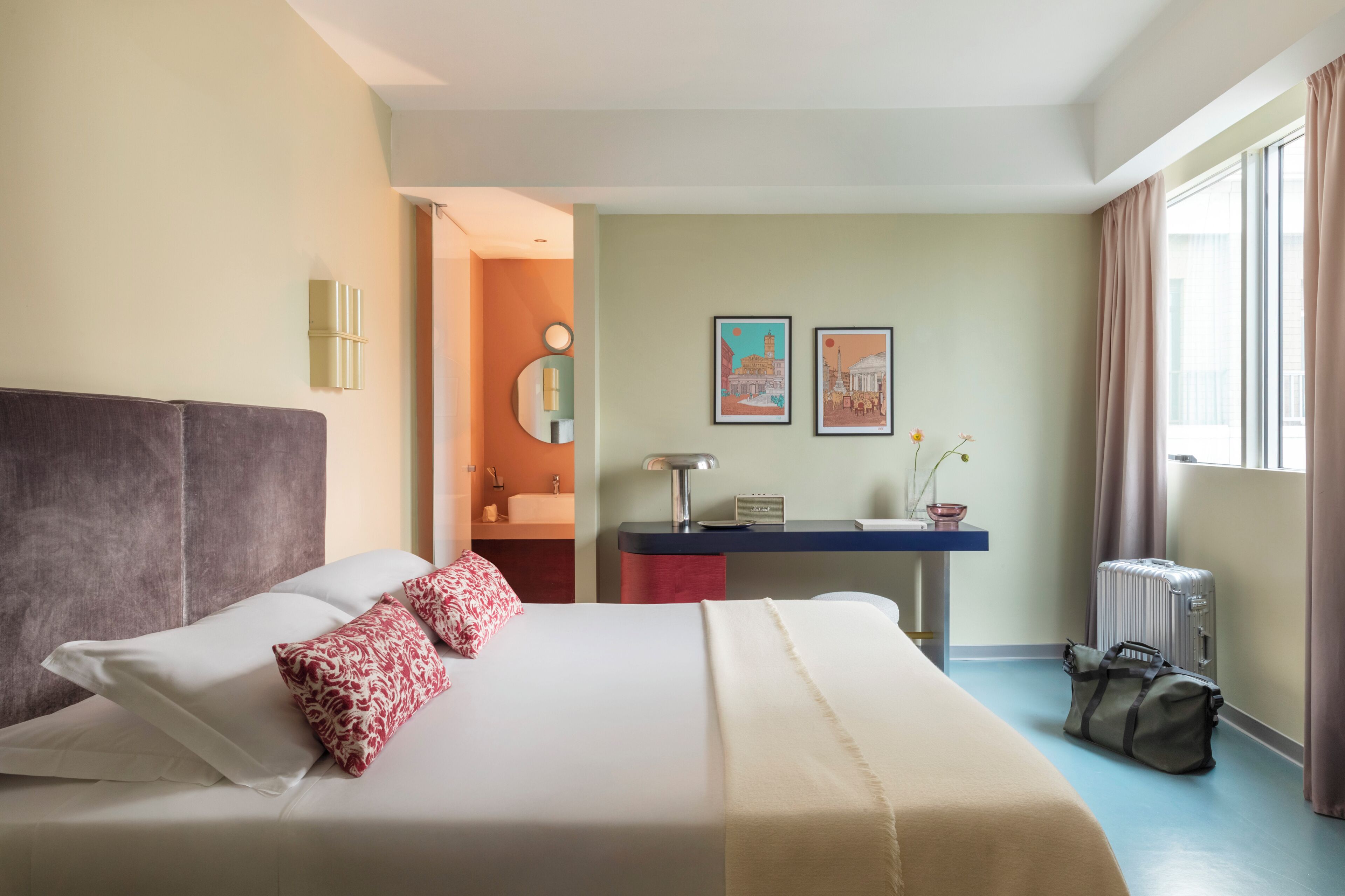 Une chambre d’hôtel avec un lit, un bureau et une fenêtre.
