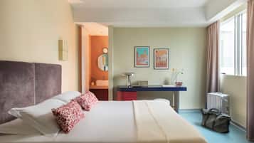 Une chambre d’hôtel avec un lit, un bureau et une fenêtre.