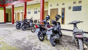 Un espace de stationnement couvert où plusieurs motos sont garées.