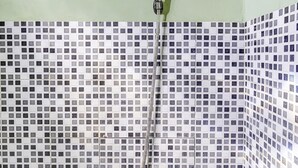 Une douche équipée d’un pommeau de douche à main et d’un flexible à main.