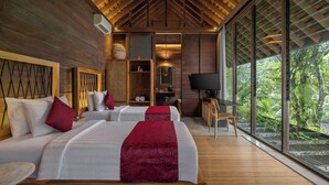 Una habitación de hotel moderna con techos de madera, ventanas amplias y dos camas con ropa de cama roja y blanca.