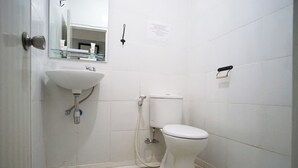 A small bathroom with a white sink, toilet, and a mirror. - OYO 91401 Almeera (Malang)