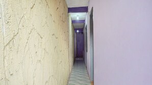 A narrow hallway with textured walls and a tiled floor. - OYO 91401 Almeera (Malang)