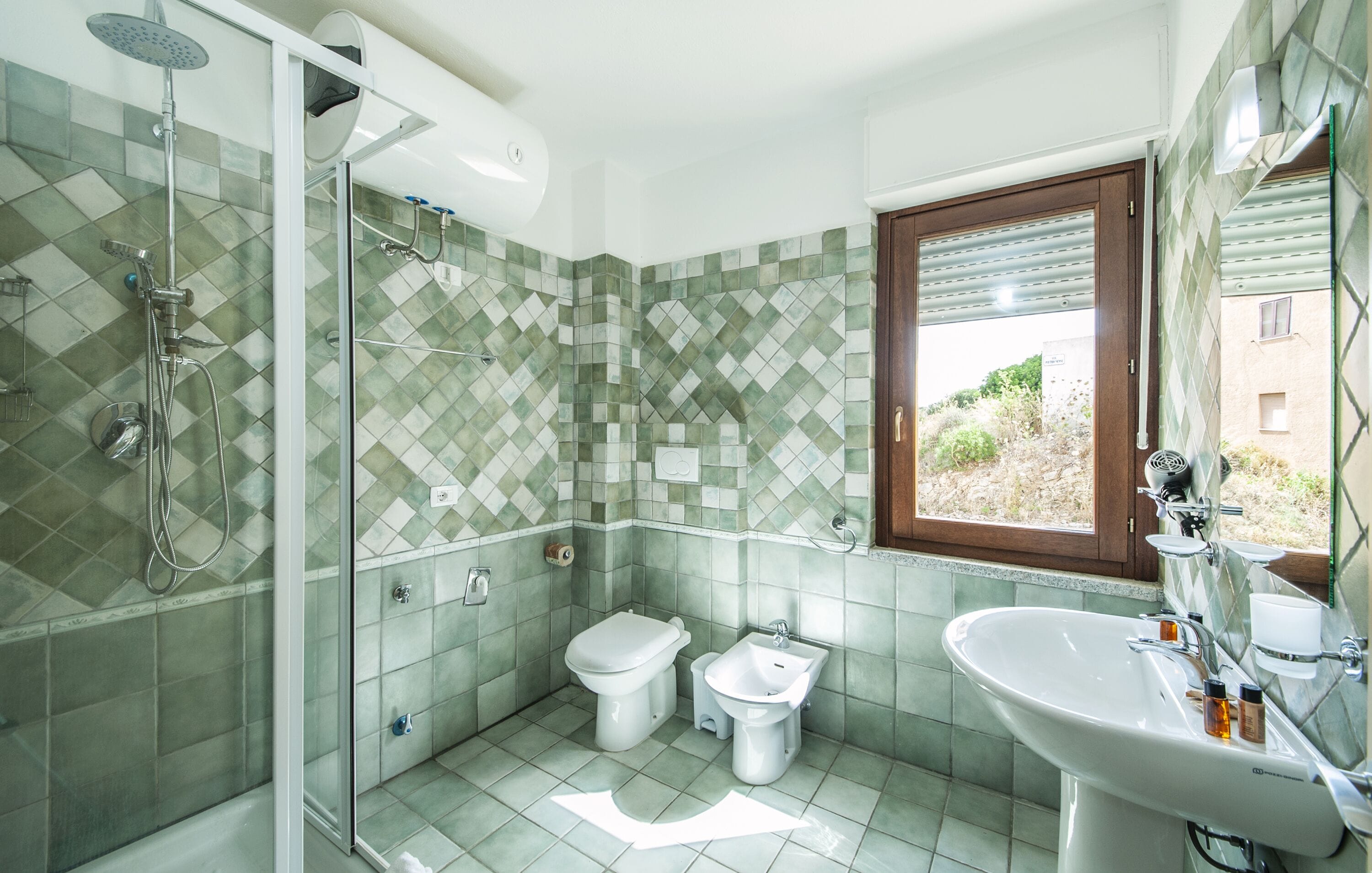 Un baño con ducha, inodoro, bidé y lavamanos.