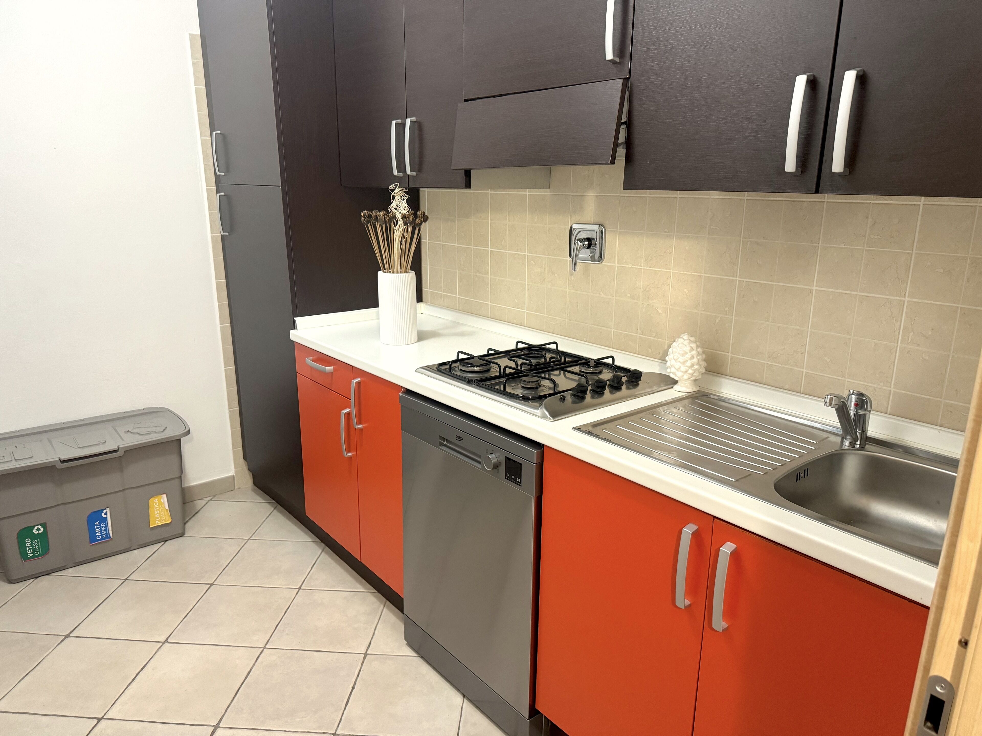 Una cocina con estufa a gas, lavaplatos y armarios.