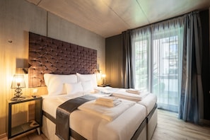 A hotel room with a large bed, a headboard, bedside lamps, and a view of the outdoors. - Onyx Luxury Budapest (Budapest)