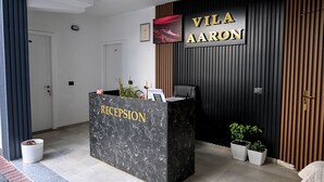 A reception desk with a sign reading "Vila Aaron" and "Reception". - VILA AARON (Durrës)