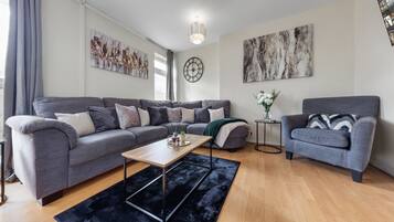 Apartamento, varias camas | Zona de estar