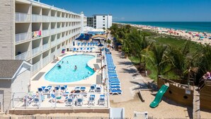 Un hôtel doté d’une piscine, d’une plage et de palmiers.