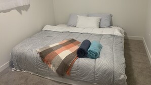 A bedroom with a bed, pillows, and a blanket. - Centrally located, Cozy two bedroom basement apartment, 10 mins from YYC airport (Calgary)