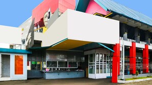 A modern building with a unique architectural design, featuring a prominent red and blue color scheme and a covered outdoor area. - SPOT ON 91765 Kaiku Guest House (Tasikmalaya)