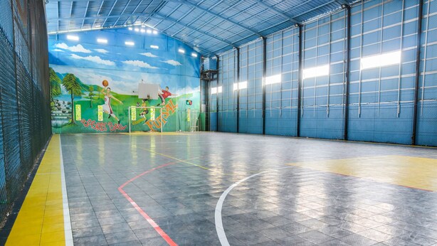 An indoor basketball court with a mural, metal walls, and a yellow line marking the boundary. - SPOT ON 91765 Kaiku Guest House (Tasikmalaya)