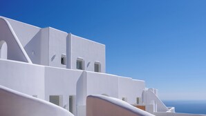 A white building with a clear blue sky and the sea in the background.