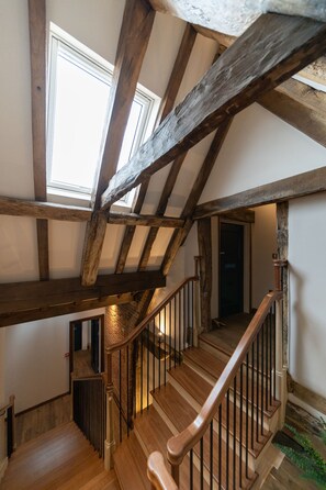 A wooden staircase with a view of the upper floor and a door at the top. - The Ironmongers Boutique (Norwich)