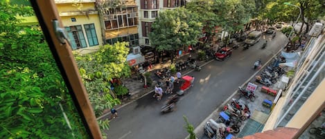 Vista de calle con edificios, árboles y motocicletas estacionadas.