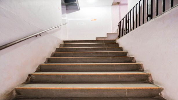 A staircase with a metal handrail and a black railing on the right side. - SPOT ON 91887 Penginapan Rindu (Batam)