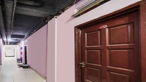A hallway with a closed wooden door marked with the number 104. - SPOT ON 91887 Penginapan Rindu (Batam)