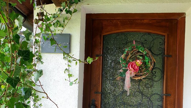 Une porte en bois ornée d’un panneau de verre décoratif et d’une guirlande.