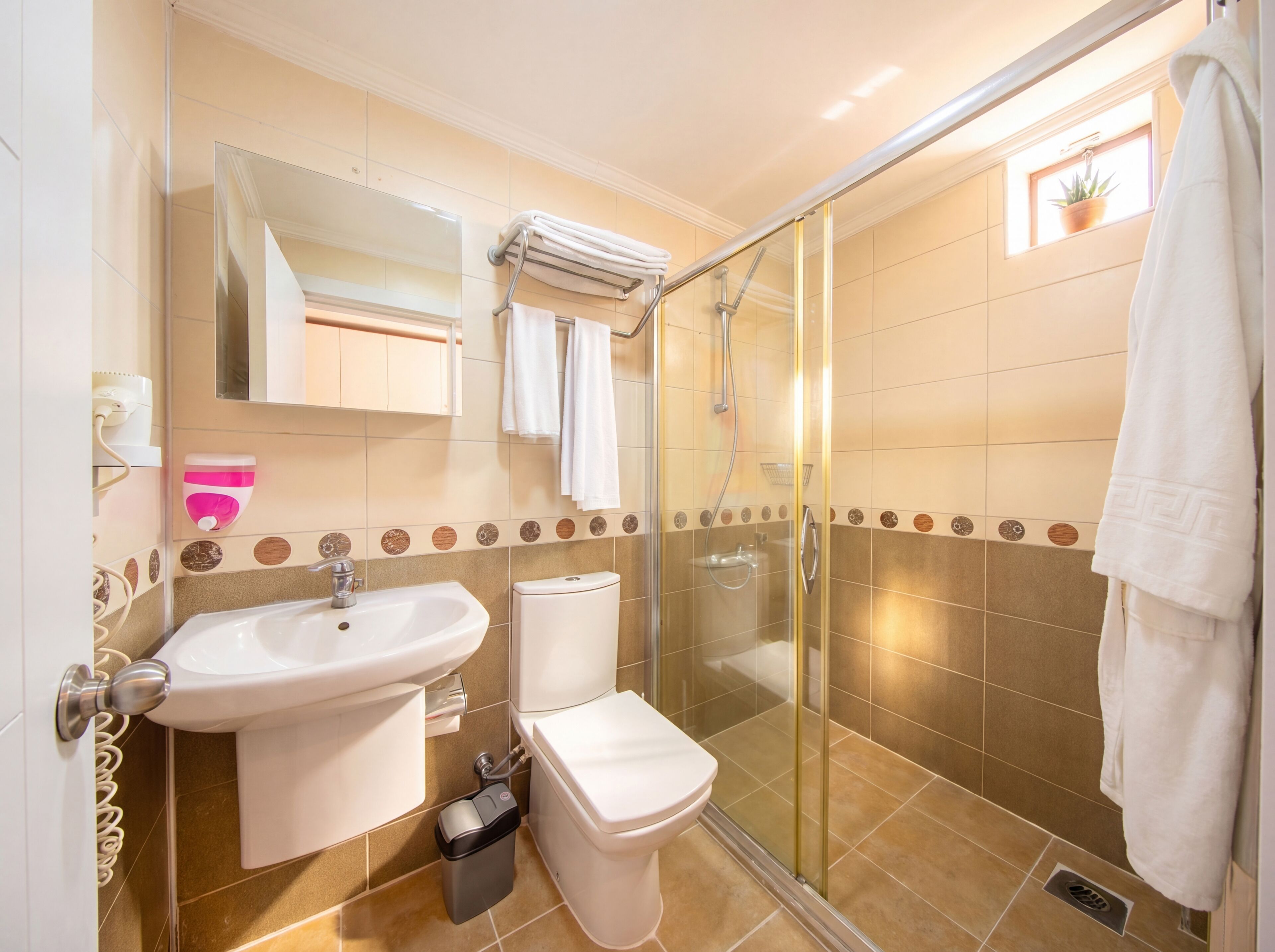 A bathroom with a sink, toilet, and shower.