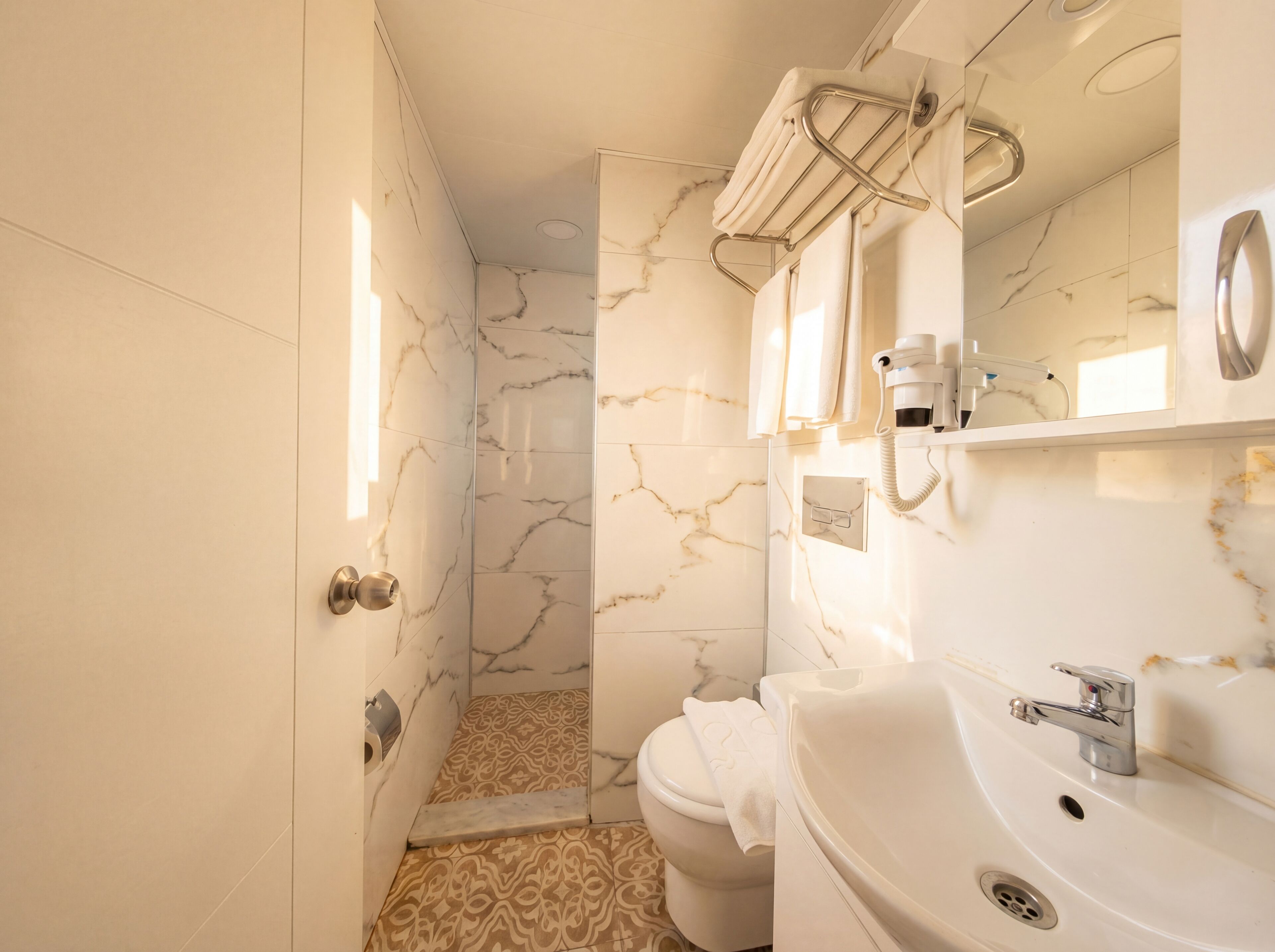 Un baño con inodoro, lavabo y zona de ducha.