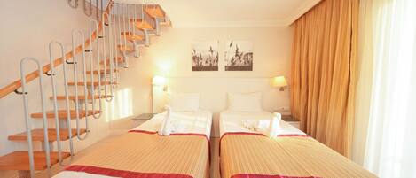 A hotel room with two beds, a staircase, and a view of the outside.