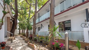 A corridor with a brick pathway, potted plants, and a metal railing. - Tropic Beach Club Side  (Manavgat)