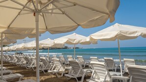 A beach with rows of white lounge chairs and large white umbrellas. - Tropic Beach Club Side  (Manavgat)