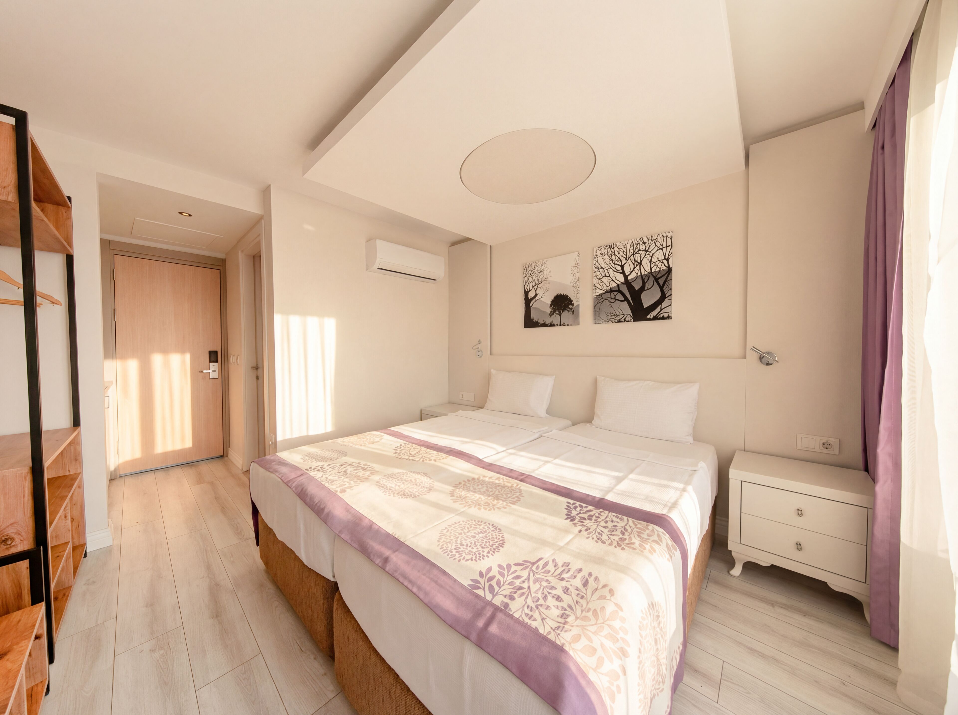 Un dormitorio con cama, mesitas de noche, armario y puerta.