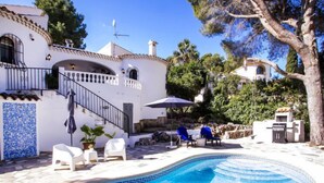 A pool area with a white building, a staircase, and outdoor seating. - Garoe Villa by Interhome (Dénia)