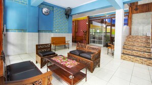 A spacious living room with a large wooden coffee table, two sofas, and a clock on the wall. - OYO Life 3720 Homestay Gayatri Janti (Malang)