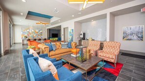 A modern lobby with a sofa, armchairs, and a coffee table. - Apt 335 · Luxury 2Bd Queen Unit | Free Parking |Hwy121| TPC (McKinney)