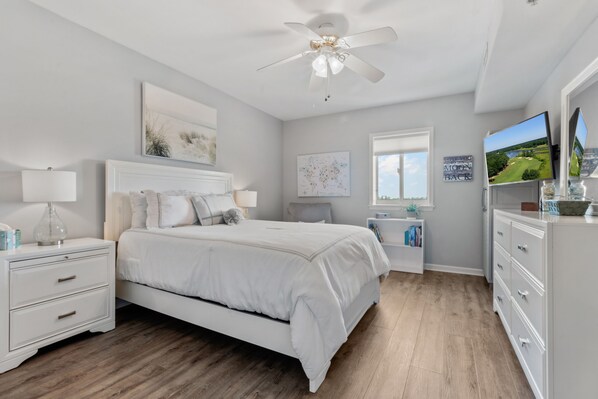 A bedroom with a bed, nightstands, a dresser, a ceiling fan, artwork, and a television. - North Tower #801 End Unit with Pool Views! (North Myrtle Beach)