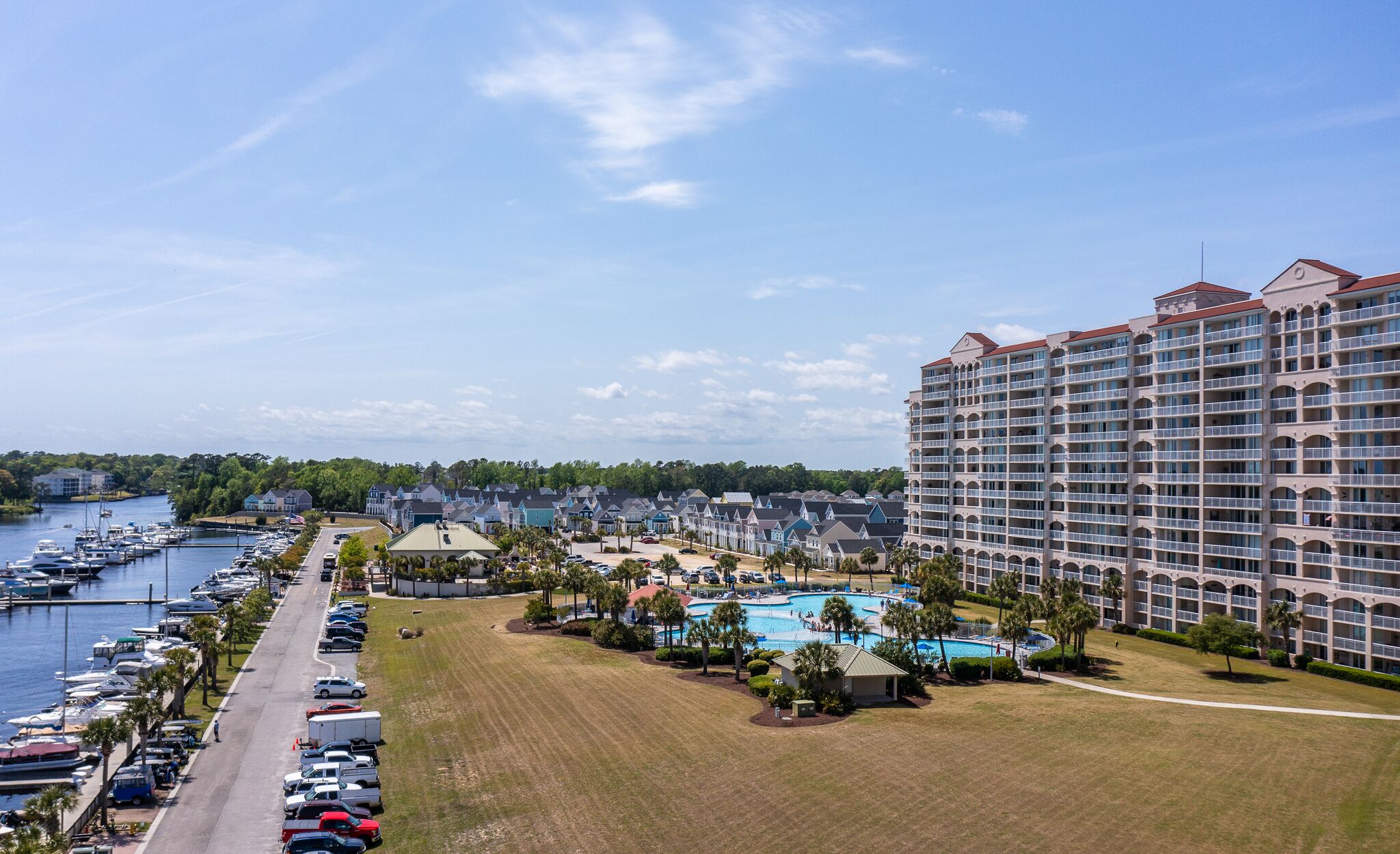 A hotel with a large pool, a marina, and a view of the water.