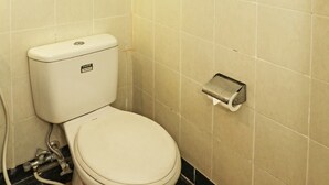 Ein kleines Badezimmer mit Toilette, Papierhandtuchspender und Handtuchhalter.